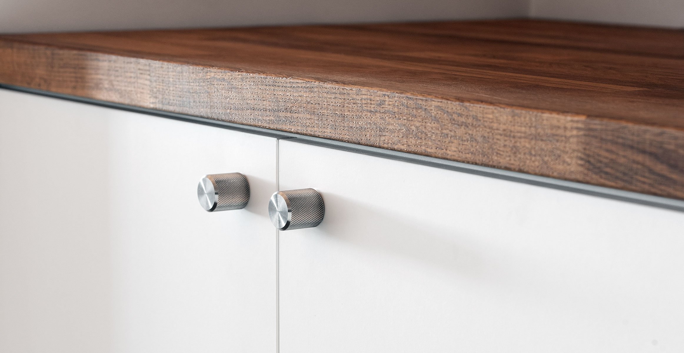 Kitchen cabinet featuring the Kor Cabinet Knob in Stainless Steel finish